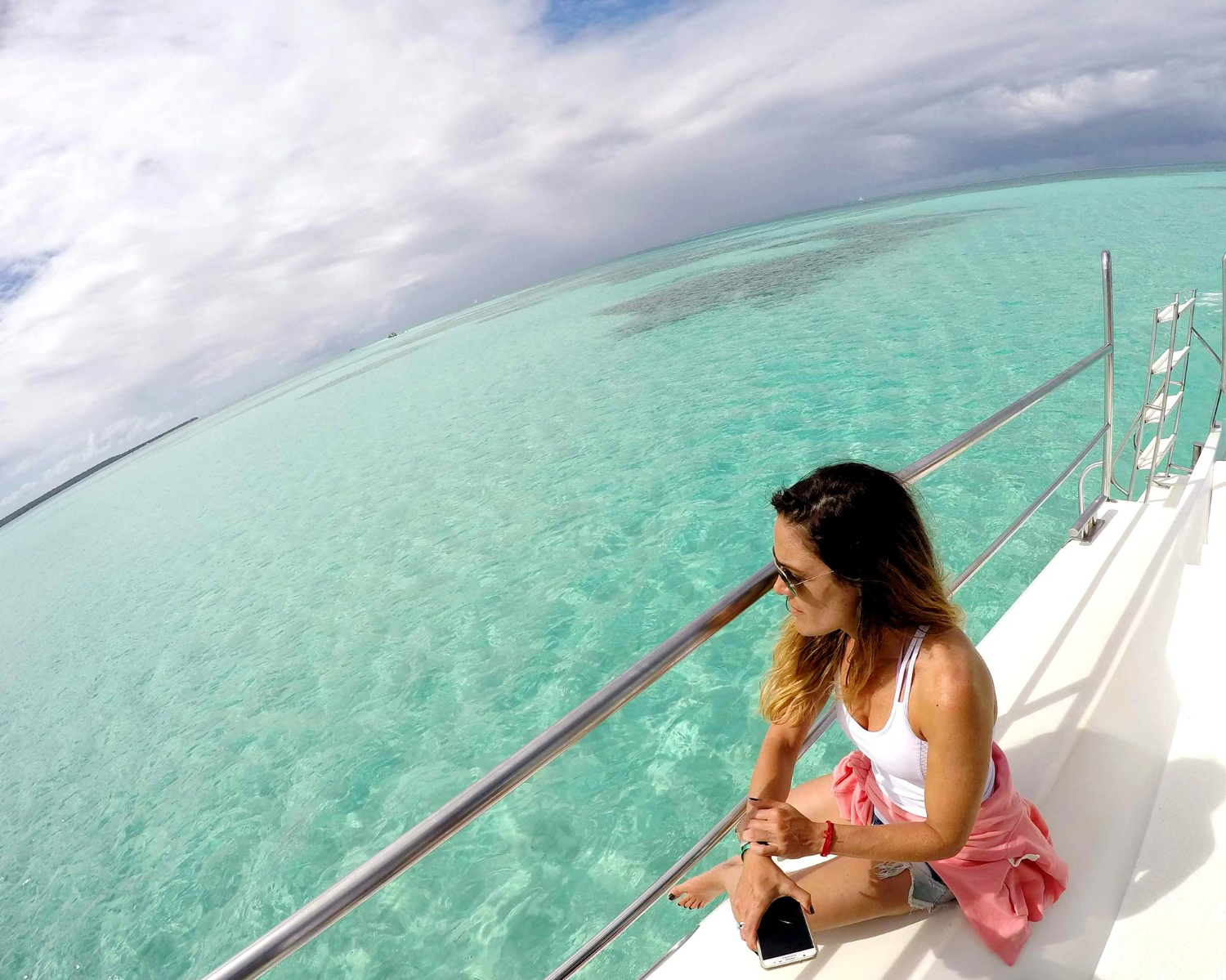 Personas disfrutando en un yate privado en Cancún con vista al mar turquesa del Caribe mexicano.